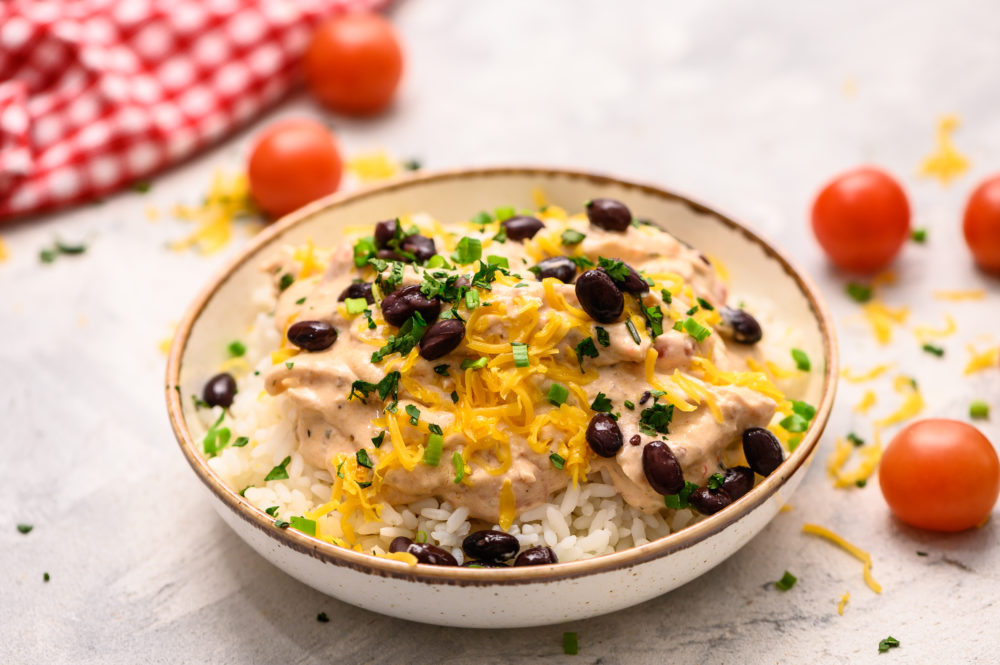 Salsa chicken on a bed of white rice with black beans over top.