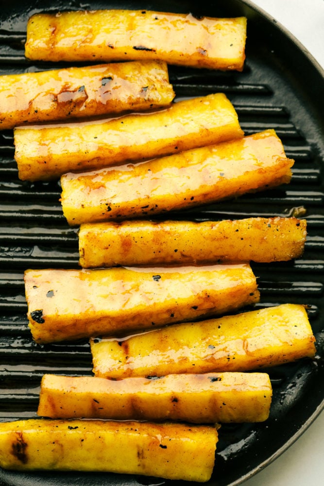 Pineapple spears on a grilling pan.