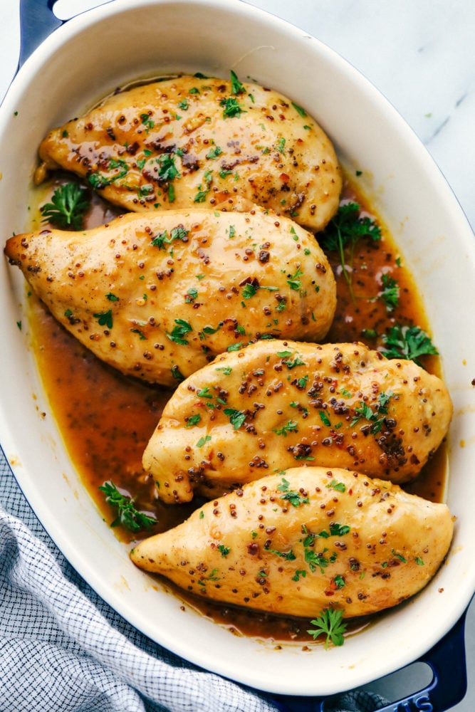 Pollo al horno con mantequilla de miel en una sartén listo para ser horneado. 