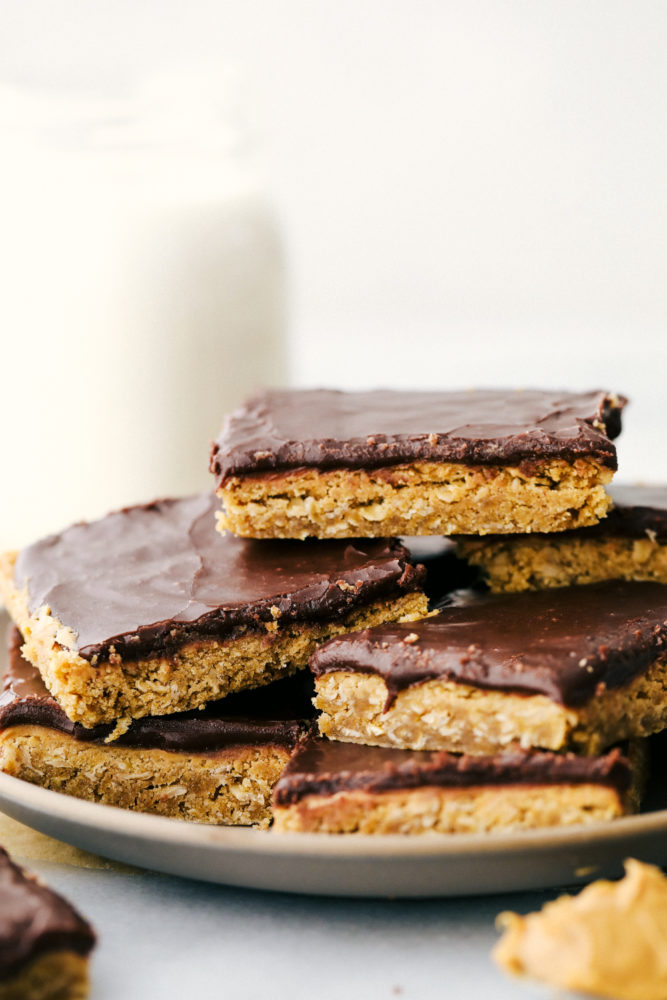 Peanut butter bars stacked on top of each other on a plate. 