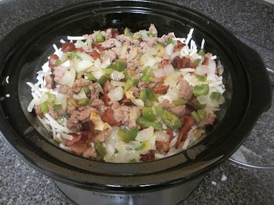 Overnight Breakfast Casserole in a crockpot before the egg is poured on it. 