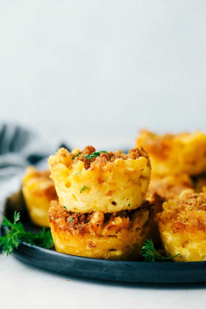Mac and cheese cups stacked on a plate.