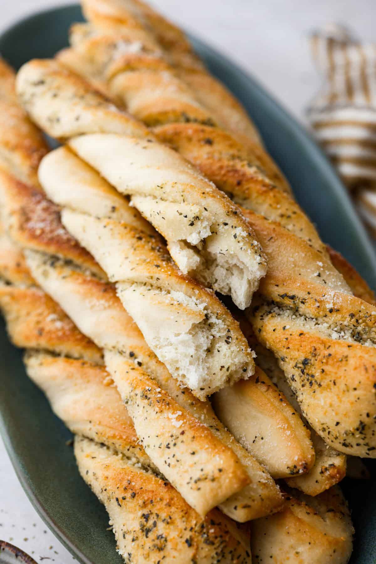 Close up shot of homemade breadtwists stacked on a plate. 