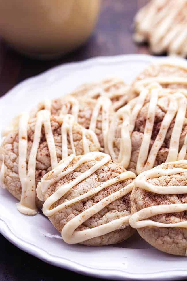 Eggnog cookies stacked on top of each other on a white plate.