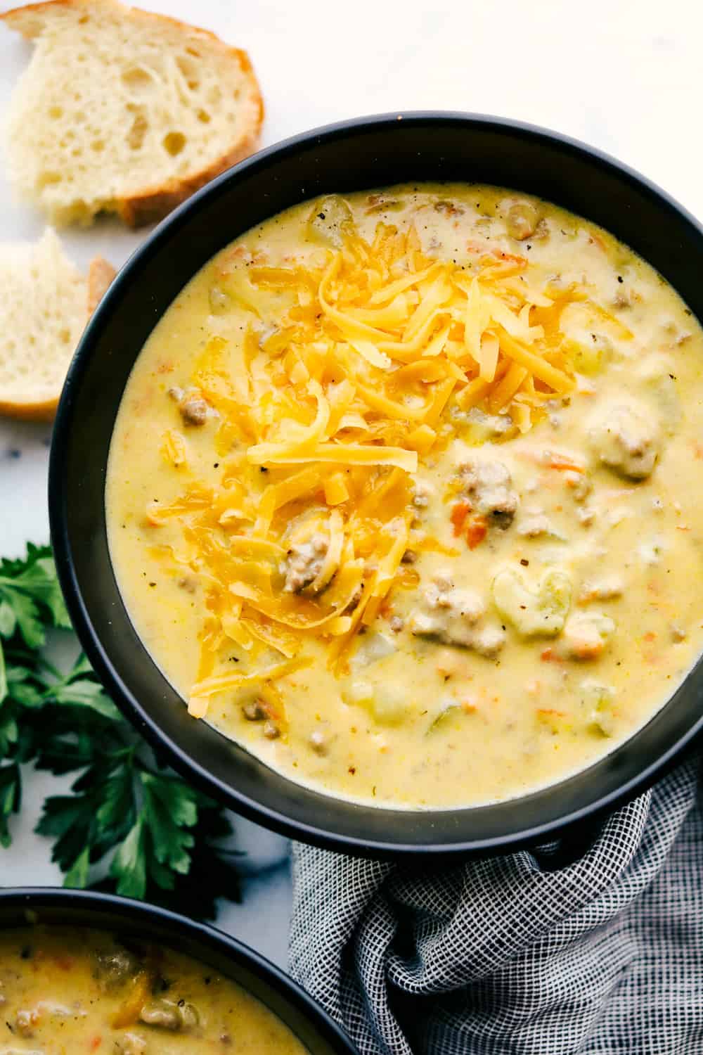 Cheeseburger soup in a bowl with shredded cheese on top.