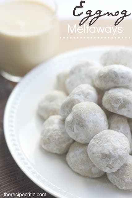 Eggnog Meltaways on a white plate with eggnog in the background