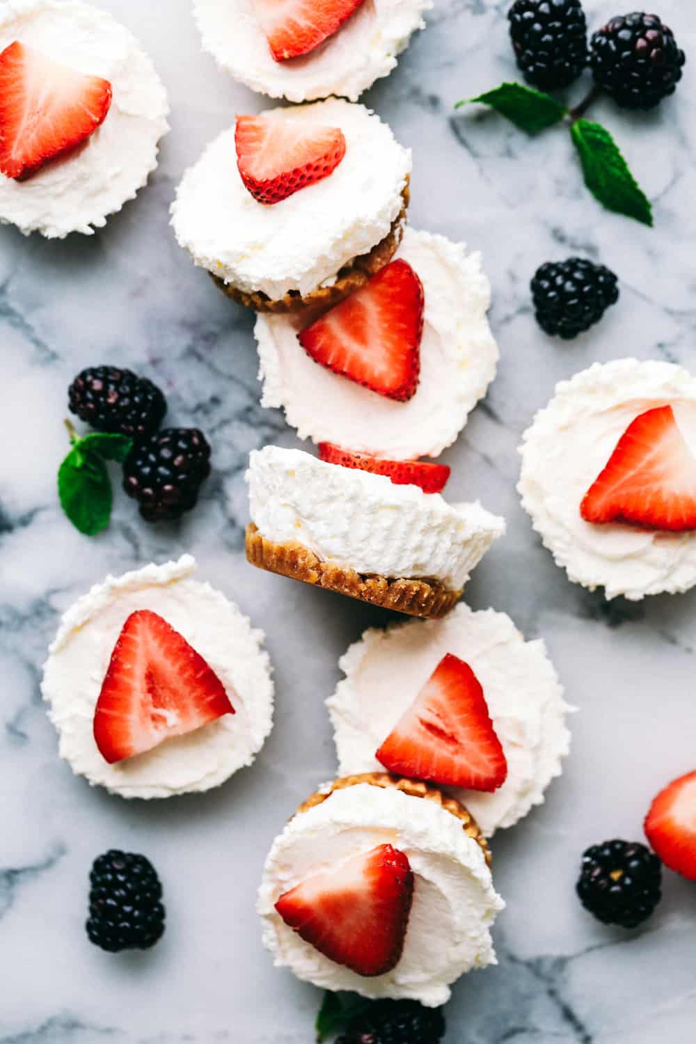 Skinny Mini Cheesecake bites on a marble counter with black berries between.