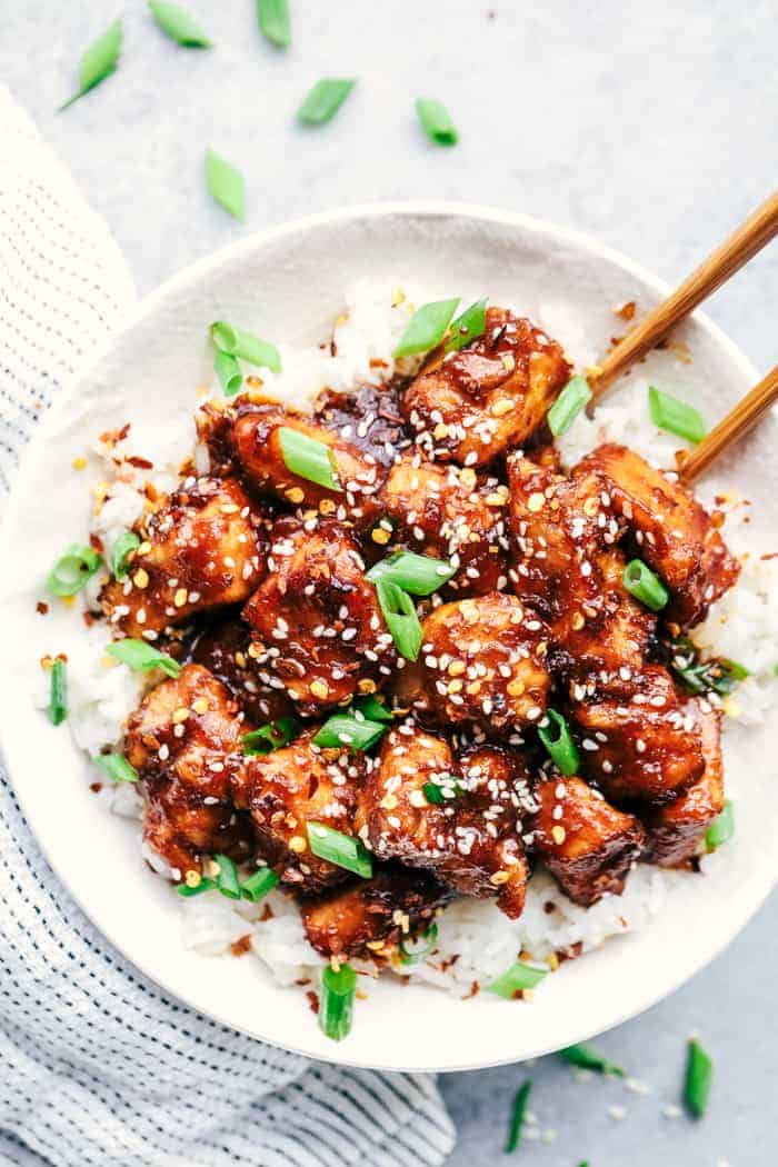 Slow Cooker General Tso's Chicken is a super easy meal with an amazing sweet and savory sauce with a little bit of heat! This is way better than takeout! Slow Cooker General Tso's Chicken in a white bowl.