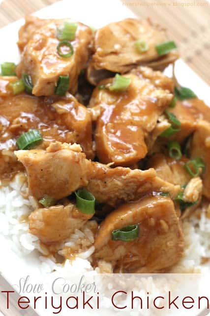 Chicken garnished with green onion and sitting on white rice.