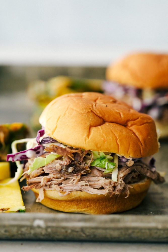 Slow Cooker Kalua Pulled Pork, tender smokey and moist, served on a bun.