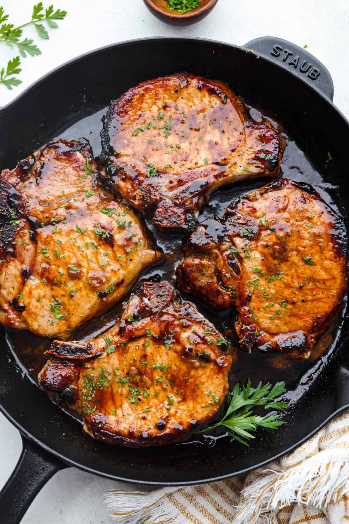 Overhead shot of brown sugar glazed pork chops in skillet.