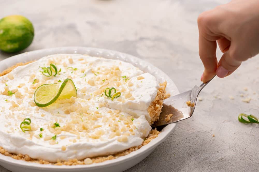 Pulling out a slice of key lime pie with a spatula.