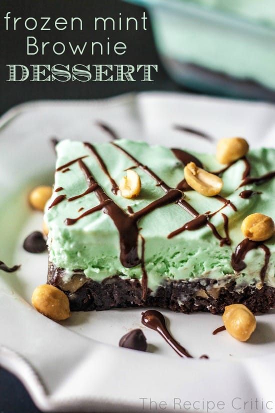 Frozen Mint brownie dessert square garnished with peanuts and a drizzle of chocolate on a white plate.