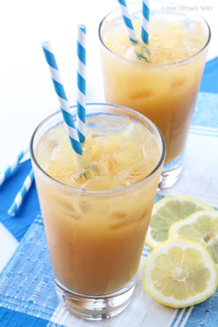 Two glasses of summertime tea with blue and white straws in each.
