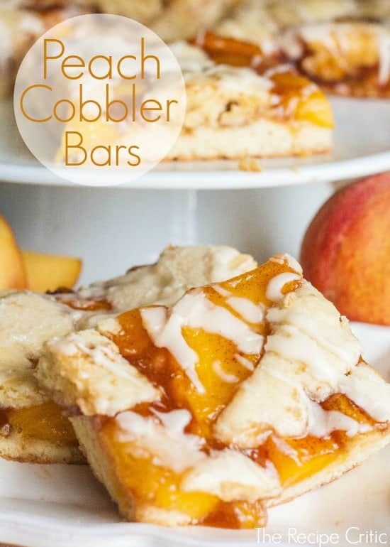 Peach cobbler bars on a white cake stand and a white plate.