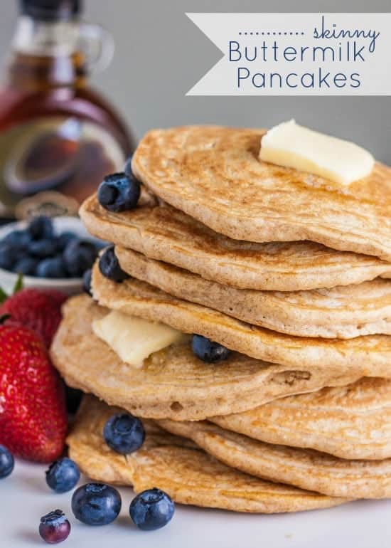 Skinny Buttermilk pancakes in a stack of 8 with blueberries and butter between each layer.