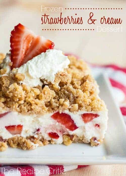 Strawberries and cream dessert bar on a white plate with cool whip and strawberry on top.