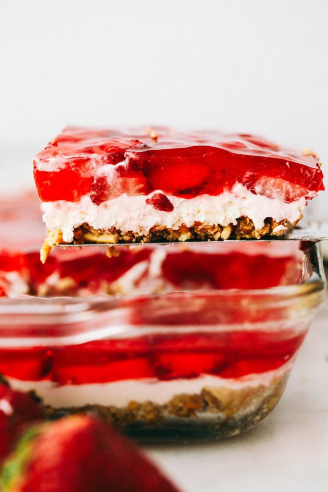 Close up on the side of a slice of strawberry pretzel salad that shows the layers.