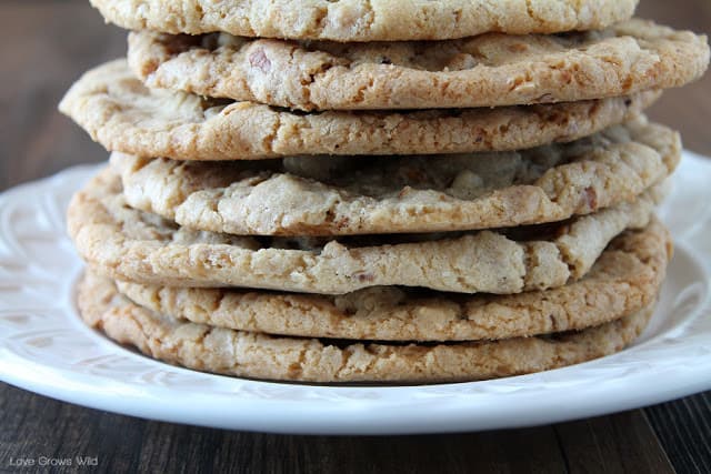 Giant White Chocolate Pecan Cookies in a stack on a white plate by Love Grows Wild for The Recipe Critic