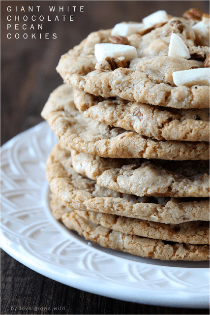 Giant White Chocolate Pecan Cookies in a stack on a white plate by Love Grows Wild for The Recipe Critic