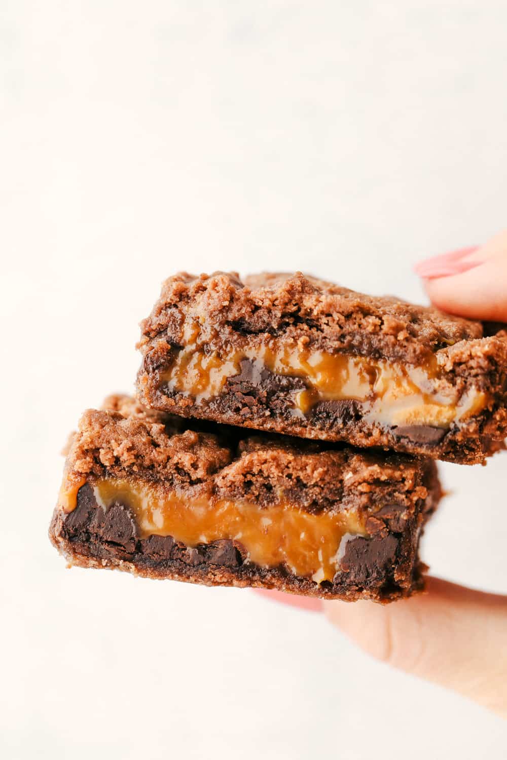 Holding two ooey gooey caramel brownies. 