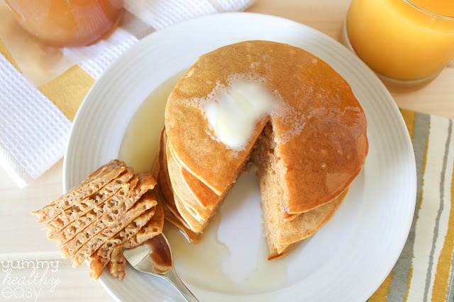 Stack of pumpkin pancakes with one bite cut out and on a fork.