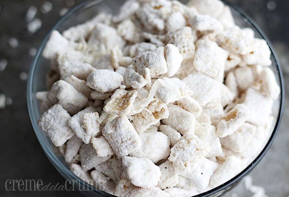 Vanilla coconut muddy buddies in a glass bowl.