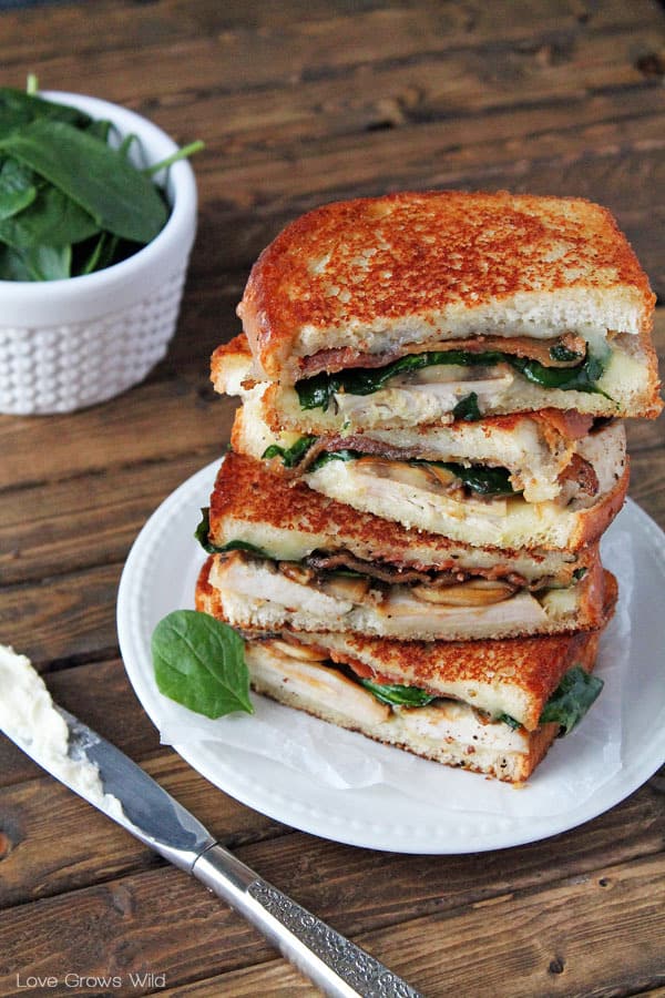 Grilled Turkey Florentine Sandwiches stacked on a white plate by Love Grows Wild for The Recipe Critic