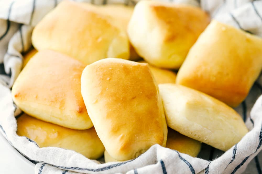 A bunch of Texas road house rolls in a basket together.