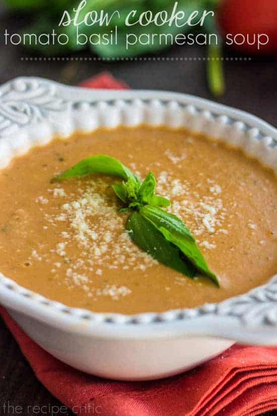 Tomato basil parmesan soup in a white bowl with green garnish.