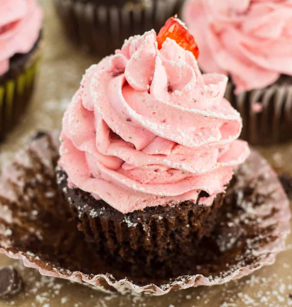 Close up of Strawberry Mousse Frosted Chocolate Cupcakes with a cupcake paper removed. 