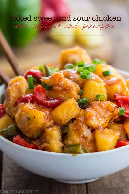 Baked Sweet and Sour Chicken with Peppers and Pineapple in a white bowl with wooden spoons. 