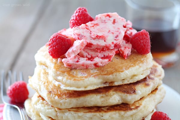 Close up of a stack of pancakes on a white plate with Raspberry Butter on top. 