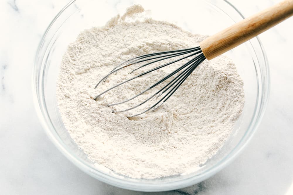 dry ingredients in a glass bowl being whisked together