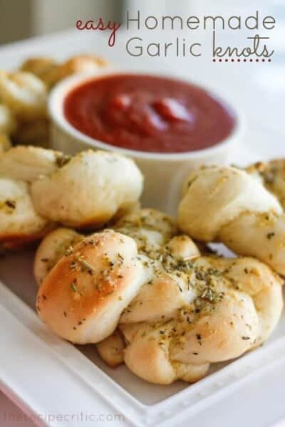 Easy Homemade Garlic Knots on a white plate with tomato sauce. 