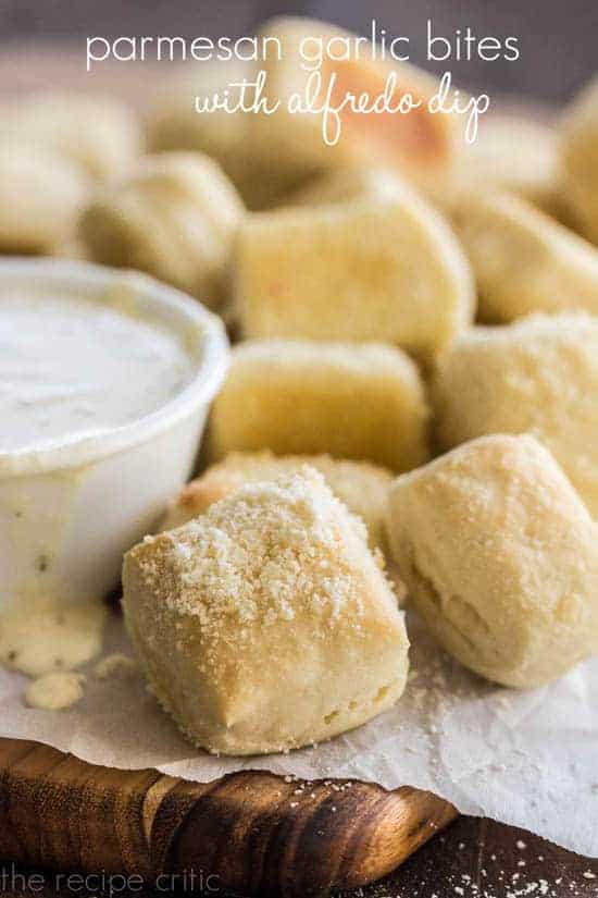 Parmesan Garlic Bites with Alfredo Dip on a wooden cutting board. 