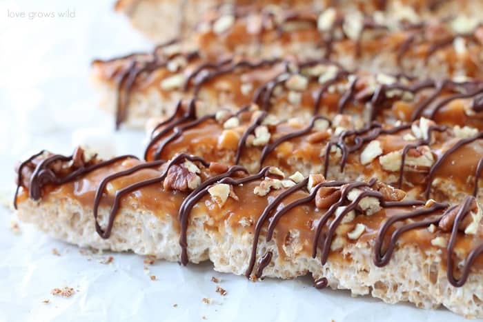 Classic rice krispie treats with a delicious turtle topping of creamy caramel, crunchy pecans, and a decadent chocolate drizzle! | Love Grows Wild for TheRecipeCritic.com