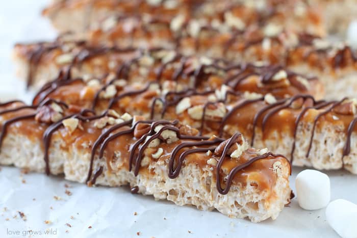 Classic rice krispie treats with a delicious turtle topping of creamy caramel, crunchy pecans, and a decadent chocolate drizzle! | Love Grows Wild for TheRecipeCritic.com