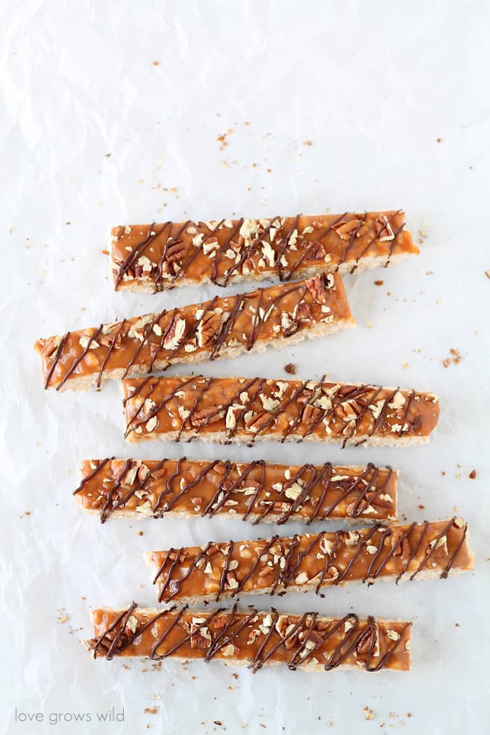 Classic rice krispie treats with a delicious turtle topping of creamy caramel, crunchy pecans, and a decadent chocolate drizzle! | Love Grows Wild for TheRecipeCritic.com