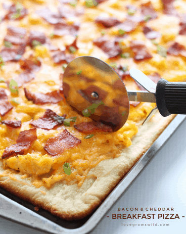 The perfect breakfast pizza topped with soft scrambled eggs, crispy bacon, and lots of melty cheddar cheese!