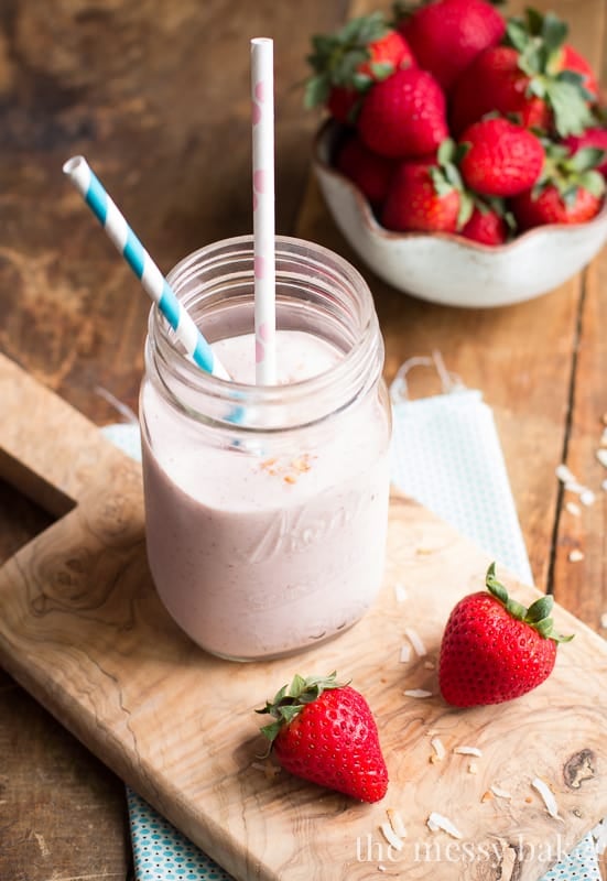 Strawberry Coconut Smoothie in a mason jar with fresh strawberries on the side. 