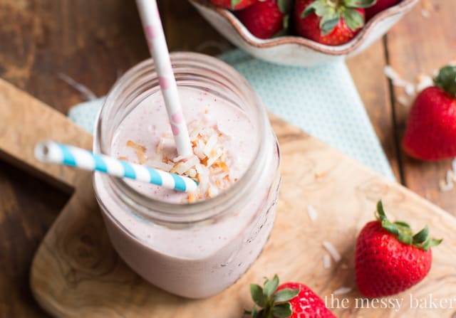 Strawberry Coconut Smoothie in a mason jar with strawberries on the side. 