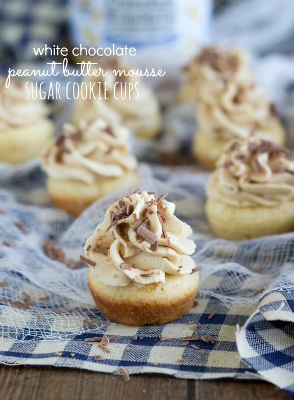 Miniature sugar cookie cups that are filled with a peanut butter mousse and garnished with chocolate shavings.