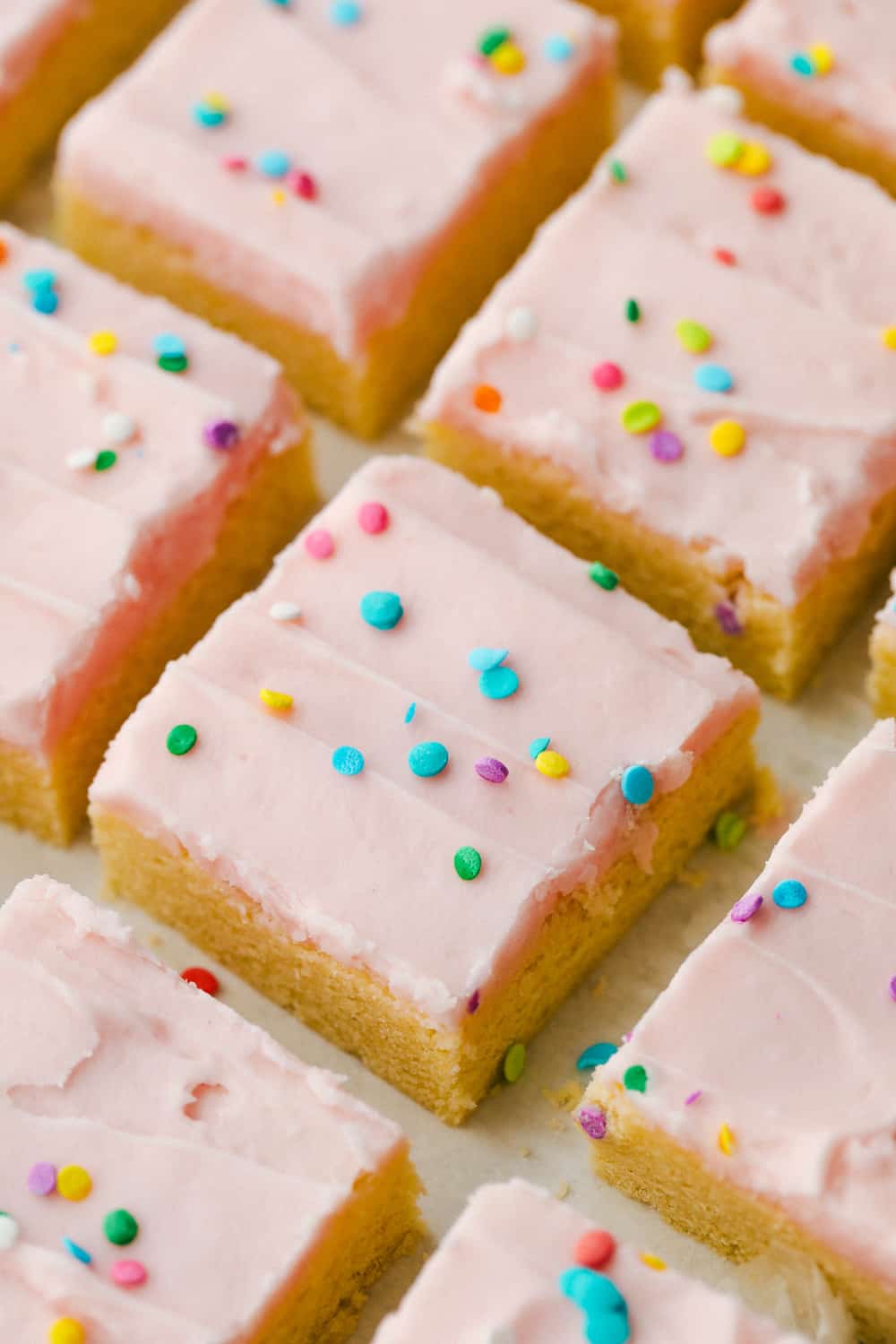 Sugar cookie bars cut into squares with sprinkles on top.