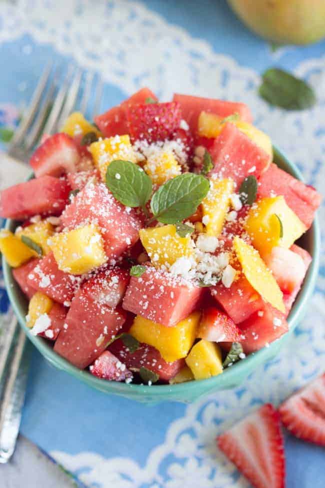 Close up overhead photo of Fresh Watermelon Feta Salad in a blue bowl with a metal fork on the side. 