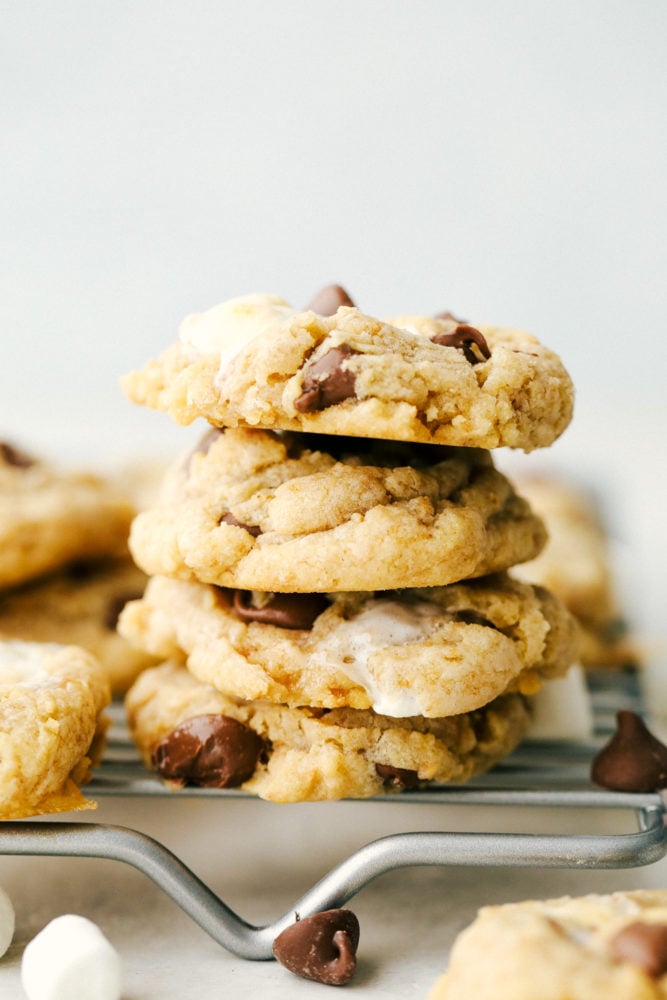 Gooey S'mores cookies stacked on top of each other resting on a cooling rack. 