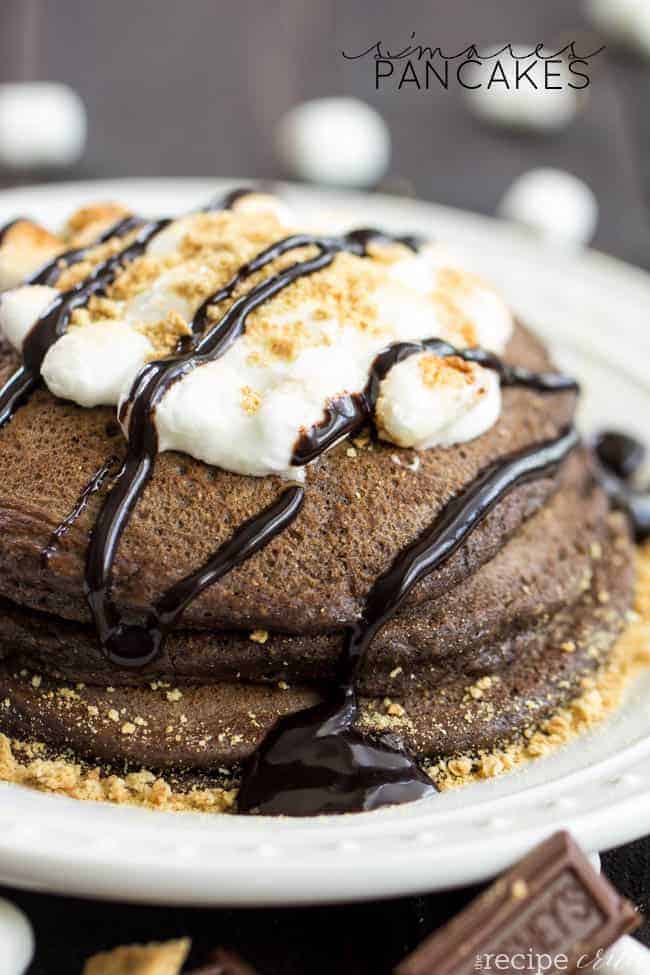 S'mores pancakes stacked on top of each other with chocolate drizzle and marshmallows.