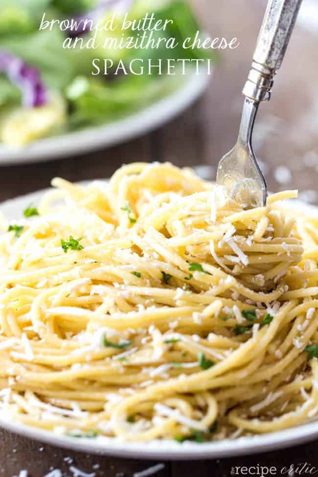 Gebräunte Butter und Mizithra-Käse-Spaghetti auf einer weißen Schüssel, wobei eine Gabel die Spaghetti dreht.