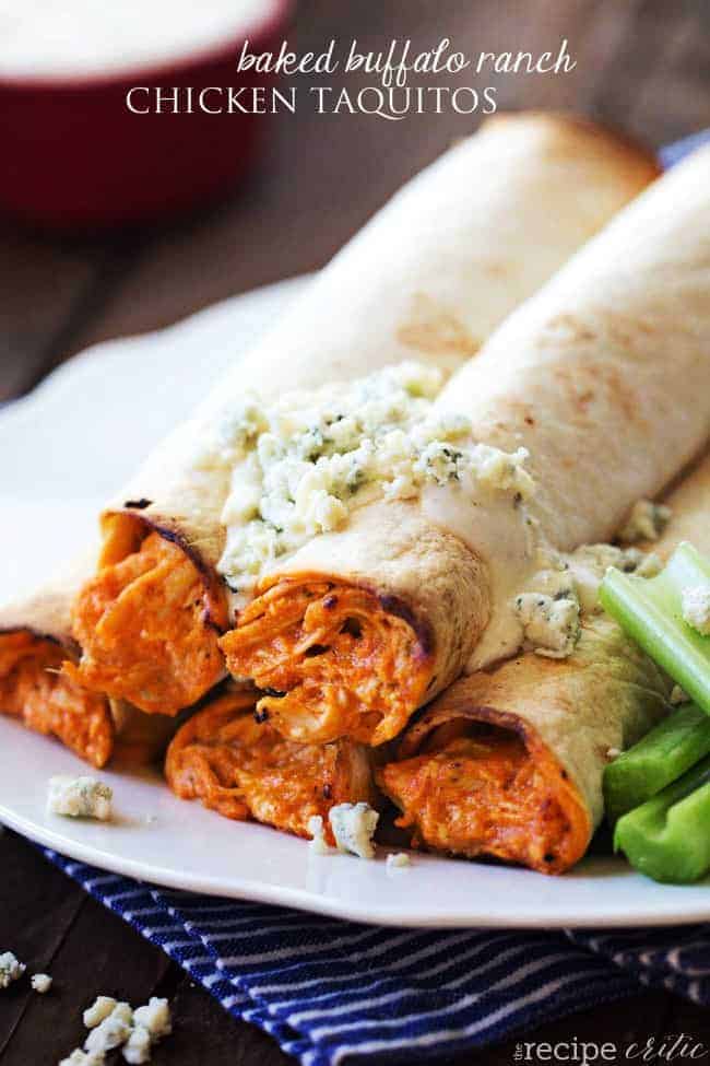 Baked buffalo ranch chicken taquitos stacked on top of each other on a white plate. 
