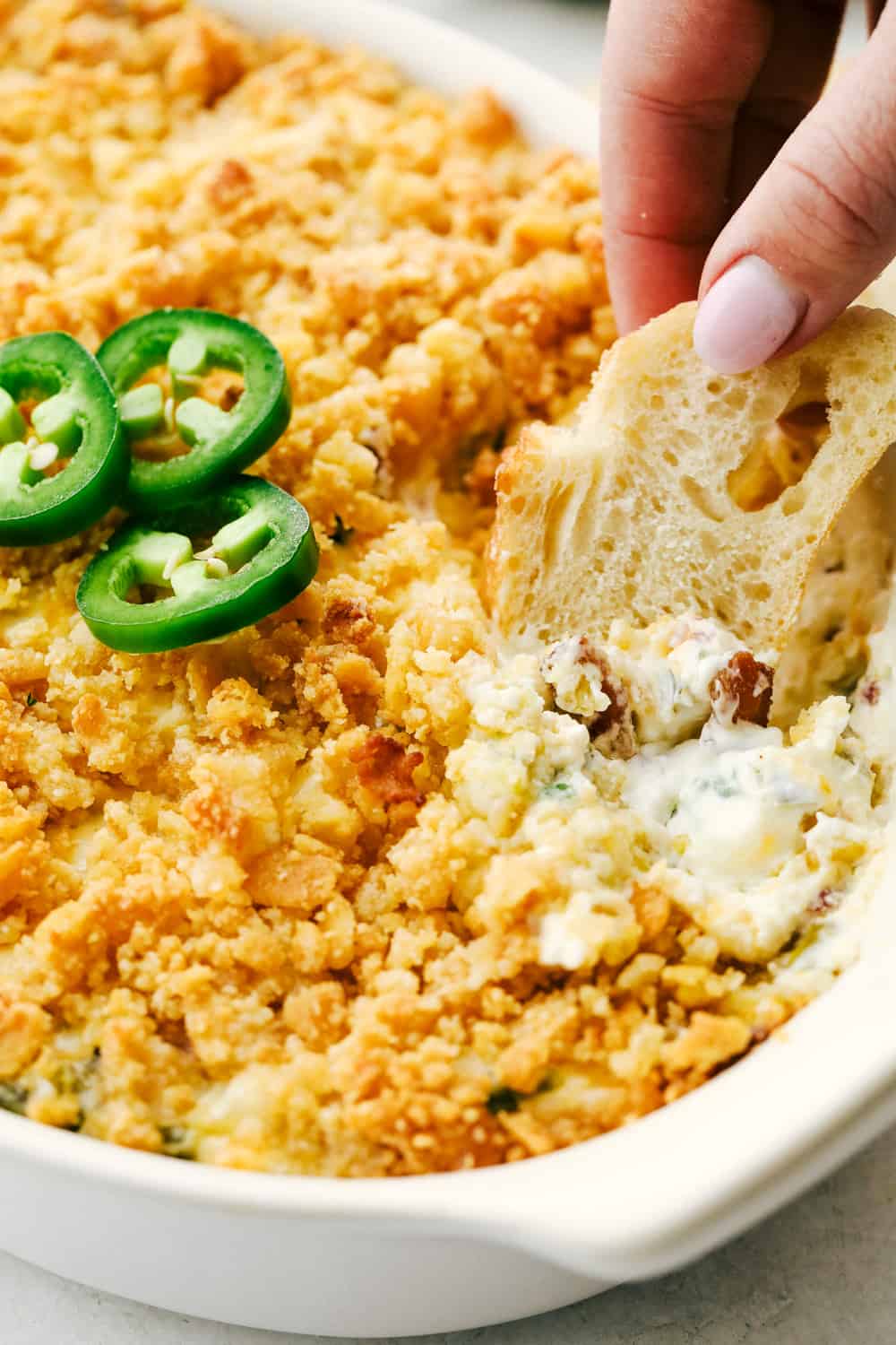 Dipping bread into the creamy jalapeno dip. 